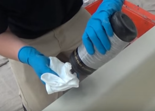 applying extra cut rubbing compound to a bathtub to polish